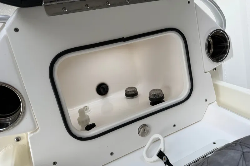 Slide: The Image of Storage compartment on a 2027 Avid 23 Mag boat, featuring multiple fittings and a latch. - 22