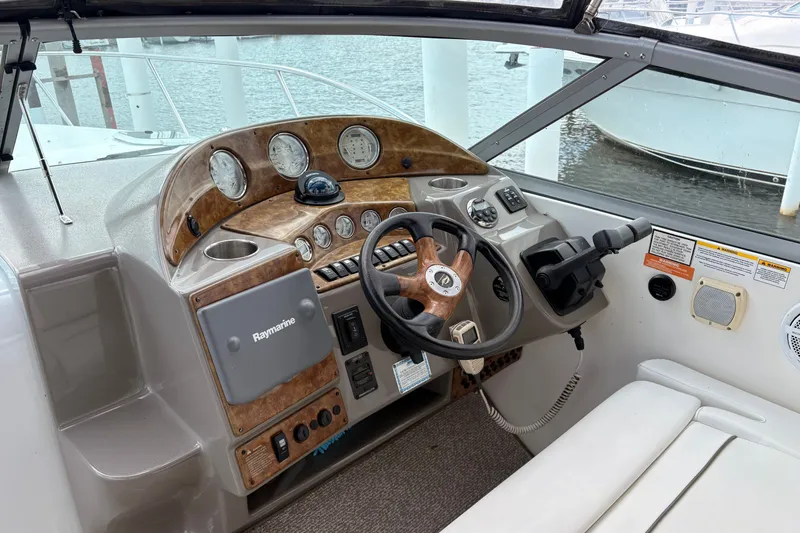 Slide: The Image of 2008 Rinker 320 Express Cruiser helm with wood accents and Raymarine electronics. - 13