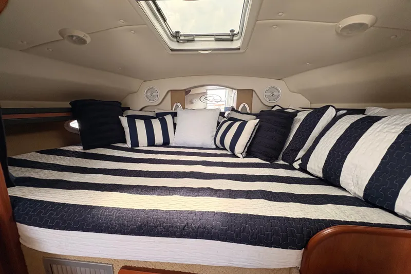 Slide: The Image of Luxurious cabin interior of 2008 Rinker 320 Express Cruiser with striped bedding. - 18