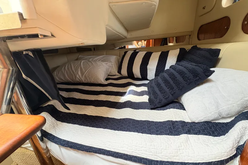 Slide: The Image of Cozy cabin interior of 2008 Rinker 320 Express Cruiser with striped bedding and pillows. - 16