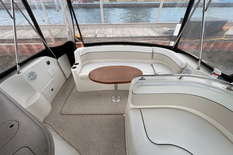 Slide: The Image of 2008 Rinker 320 Express Cruiser interior with white seating and wooden table. - 8