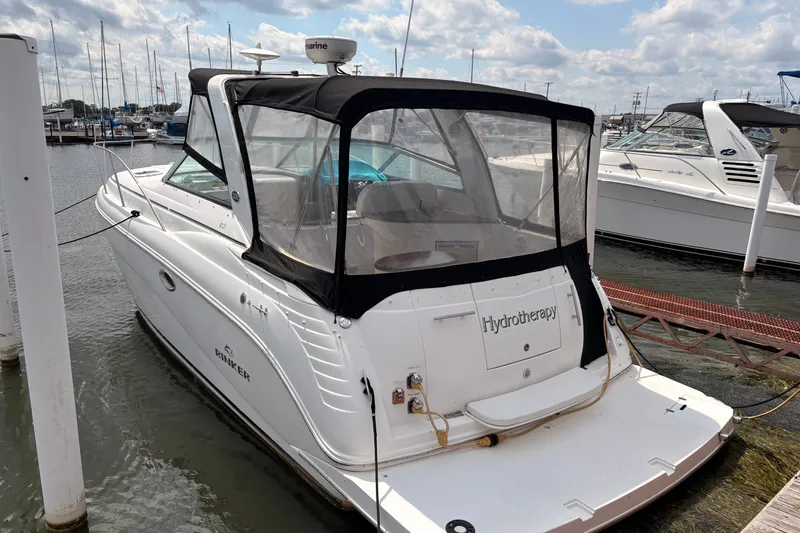 Slide: The Image of 2008 Rinker 320 Express Cruiser docked at marina under cloudy sky. - 5