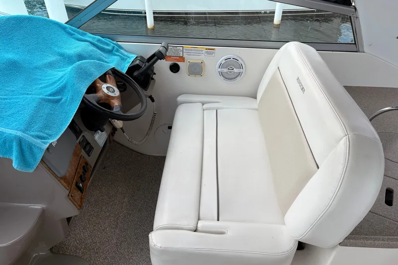 Slide: The Image of 2008 Rinker 320 Express Cruiser helm with white seating and steering wheel. - 12