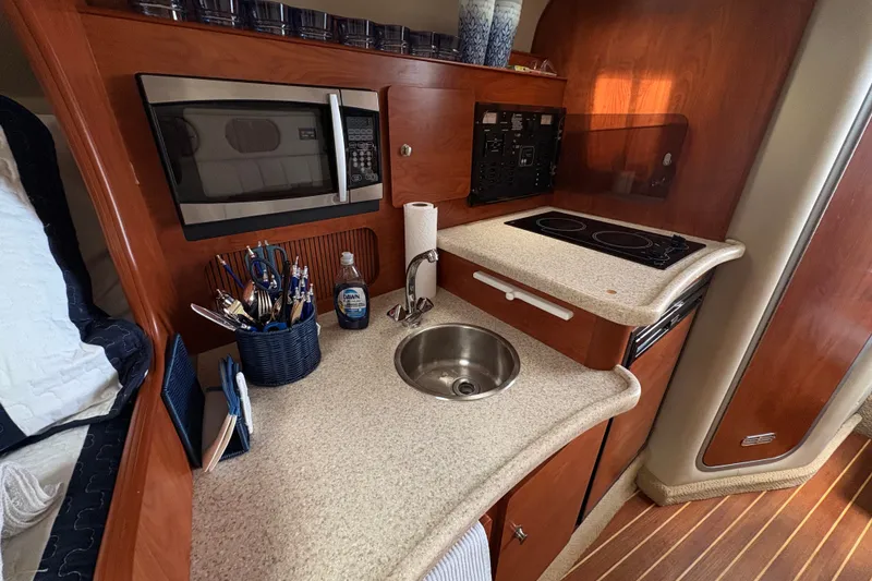 Slide: The Image of 2008 Rinker 320 Express Cruiser kitchen with microwave, sink, and stove. - 19