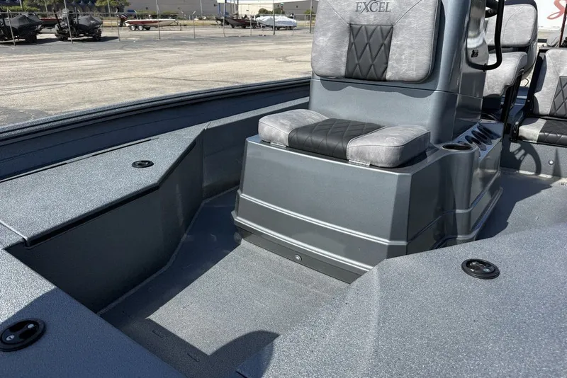 Slide: The Image of 2027 Excel 203 Bay Pro Elite boat interior with gray seating and storage compartments. - 18