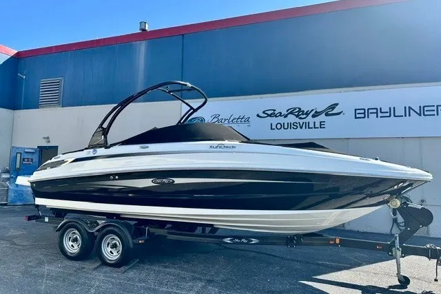The Image of 2013 Sea Ray 240 Sundeck boat on trailer, parked outside dealership in Louisville. - 1