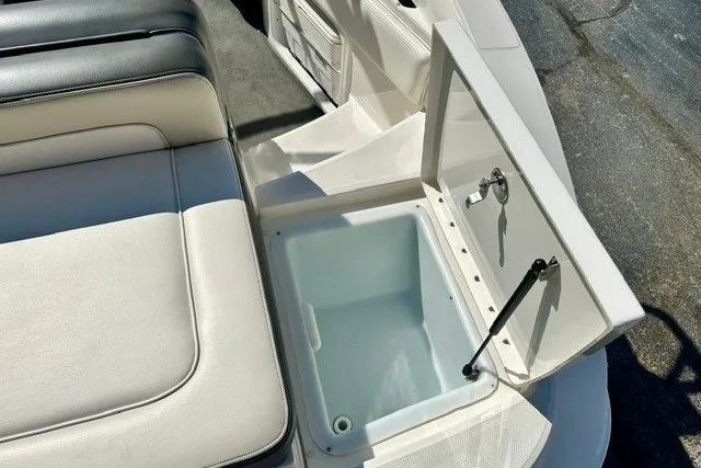 Slide: The Image of 2013 Sea Ray 240 Sundeck boat with open storage compartment and cushioned seating. - 18