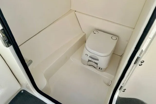 Slide: The Image of 2013 Sea Ray 240 Sundeck boat interior with compact marine toilet. - 20