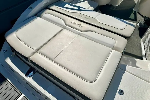 Slide: The Image of 2013 Sea Ray 240 Sundeck boat interior with cushioned seating and sun pad. - 15