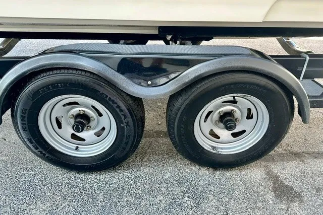 Slide: The Image of Trailer wheels for 2013 Sea Ray 240 Sundeck boat on pavement. - 24