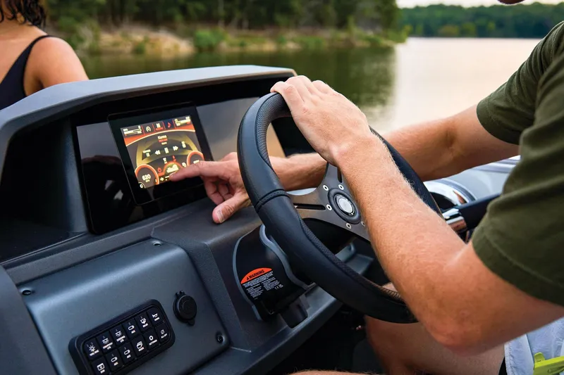 Slide: The Image of Manufacturer Provided Image: Man operating touchscreen on 2026 Sun Tracker Party Barge 22 XP3 boat dashboard. - 16