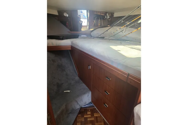 Slide: The Image of Interior cabin of 1990 Tiara 3300 Open boat with wooden cabinetry and fishing rods. - 7