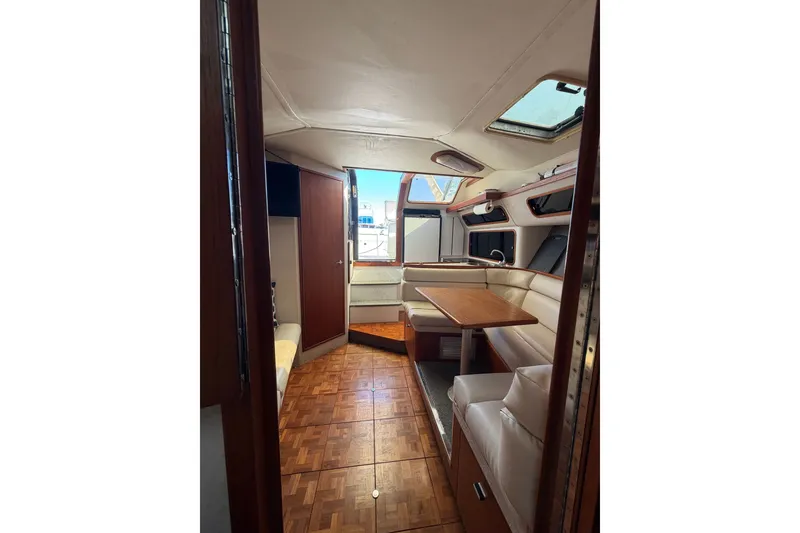 Slide: The Image of Interior of 1990 Tiara Yachts 3300 Open, featuring wood flooring and a cozy seating area. - 17