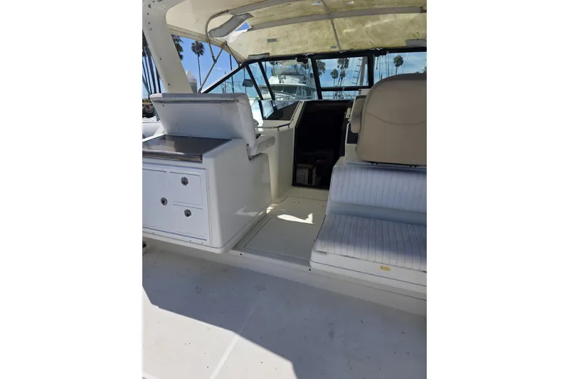 Slide: The Image of 1990 Tiara 3300 Open boat interior with seating and helm, featuring a sunny deck. - 3