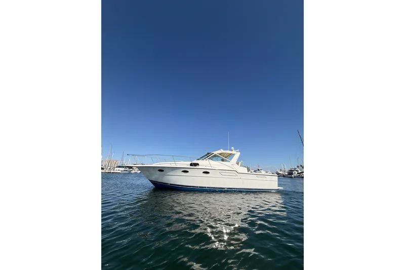 The Image of 1990 Tiara Yachts 3300 Open boat on calm water under clear blue sky. - 0