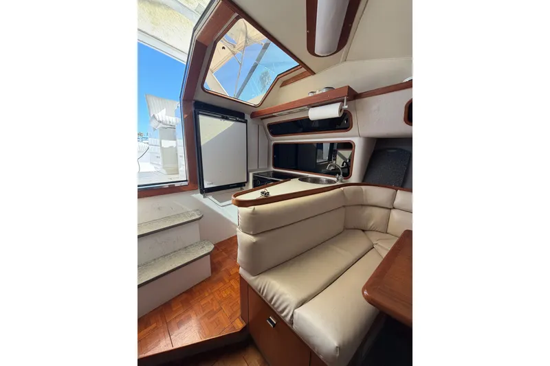 Slide: The Image of Interior of 1990 Tiara Yachts 3300 Open, featuring seating and kitchenette area. - 16