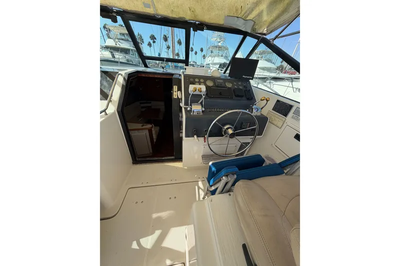 Slide: The Image of 1990 Tiara Yachts 3300 Open cockpit with steering wheel and control panel. - 18