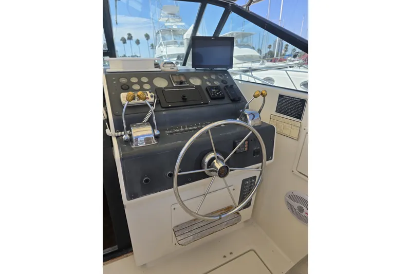 Slide: The Image of 1990 Tiara 3300 Open boat helm with steering wheel and control panel. - 5