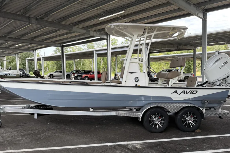 Slide: The Image of 2027 Avid 22 Recon boat on trailer under covered parking. - 1
