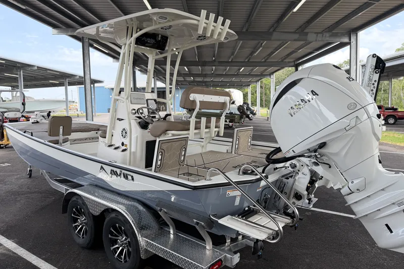 Slide: The Image of Avid 22 Recon 2027 boat with Yamaha engine on a trailer under a canopy. - 7