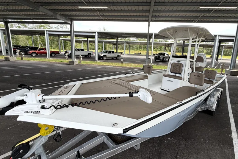 Slide: The Image of 2027 Avid 22 Recon boat with Minn Kota motor in a covered parking area. - 2