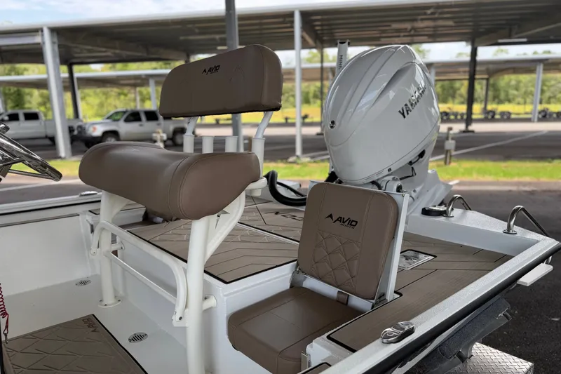 Slide: The Image of 2027 Avid 22 Recon boat interior with Yamaha engine, featuring brown seating and deck. - 12