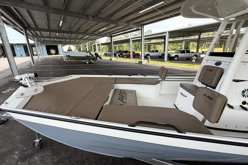 Slide: The Image of Avid 22 Recon 2027 boat with cushioned seating, parked under a covered area. - 10