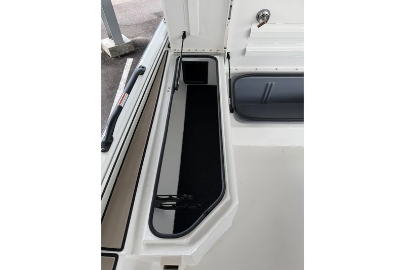 Slide: The Image of Avid 22 Recon 2027 boat storage compartment with open hatch and black interior. - 33