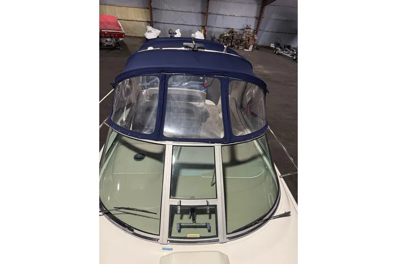 Slide: The Image of 2006 Sea Ray 300 Sundancer boat with blue canopy in indoor storage. - 7