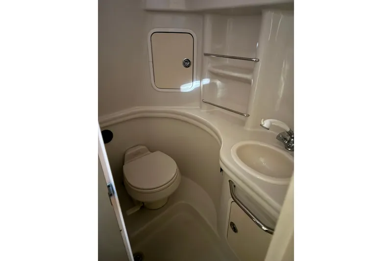 Slide: The Image of Compact bathroom in 2006 Sea Ray 300 Sundancer yacht, featuring toilet and sink. - 17