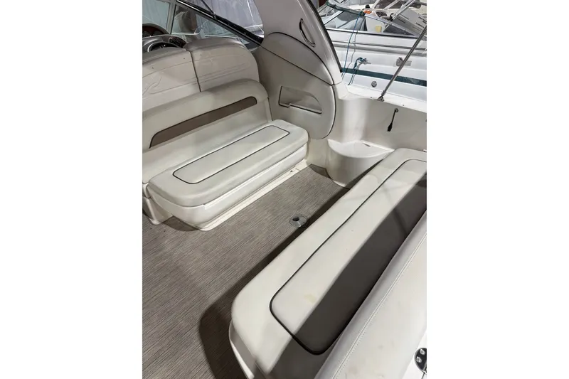 Slide: The Image of Interior seating of 2006 Sea Ray 300 Sundancer boat, featuring white cushioned benches. - 6