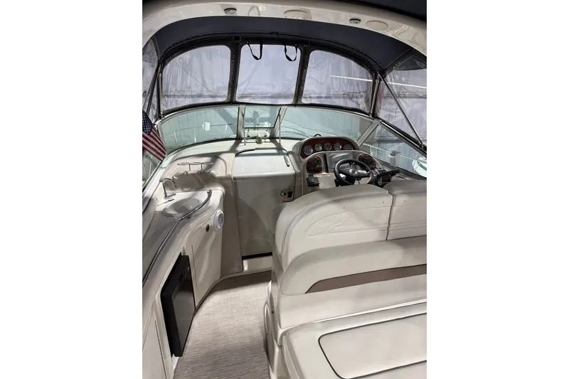 Slide: The Image of Interior view of 2006 Sea Ray 300 Sundancer boat cockpit with steering wheel and seating. - 5