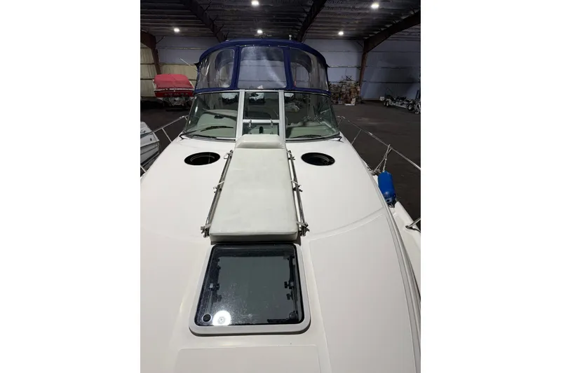 Slide: The Image of 2006 Sea Ray 300 Sundancer boat in indoor storage, featuring a sleek deck design. - 15