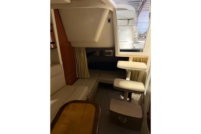 Slide: The Image of Interior of 2006 Sea Ray 300 Sundancer, featuring cozy seating and compact stairs. - 9