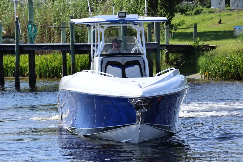 Slide: The Image of 2018 Renegade 33 Open boat cruising on a calm river near a dock. - 29