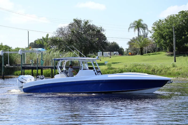 Slide: The Image of 2018 Renegade 33 Open boat cruising on a calm river with lush greenery. - 28