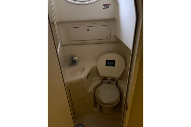 Slide: The Image of Compact bathroom in 2002 Sea Ray 410 Sundancer yacht, featuring toilet and sink. - 30