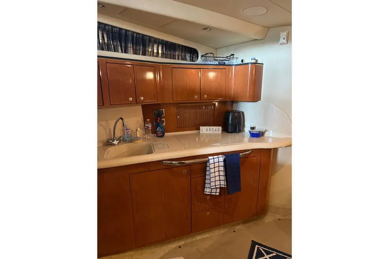 Slide: The Image of 2002 Sea Ray 410 Sundancer yacht kitchen with wooden cabinets and modern appliances. - 27