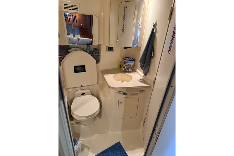 Slide: The Image of Bathroom interior of 2002 Sea Ray 410 Sundancer yacht, featuring toilet and sink. - 25