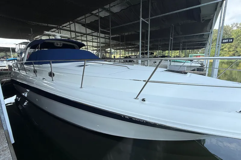 The Image of 2002 Sea Ray 410 Sundancer yacht docked in a marina under a covered structure. - 14