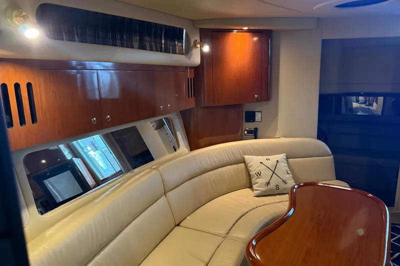 Slide: The Image of Luxurious interior of 2002 Sea Ray 410 Sundancer yacht with plush seating and wooden cabinetry. - 24