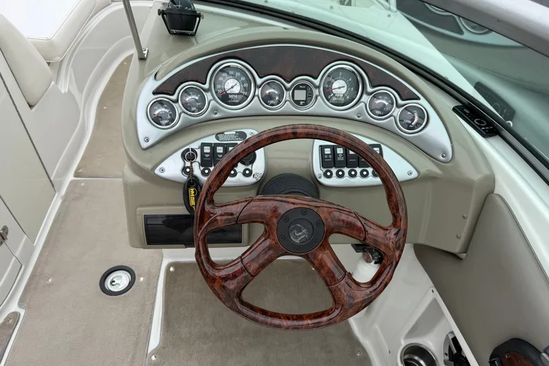 Slide: The Image of 2007 Crownline 240 EX boat dashboard with wood-grain steering wheel and instrument panel. - 15