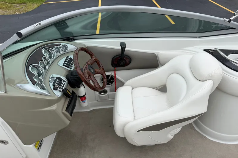 Slide: The Image of 2007 Crownline 240 EX boat cockpit with white seat and wood-grain steering wheel. - 18