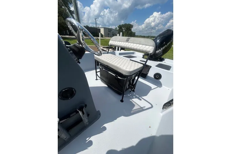 Slide: The Image of 2025 Carolina Skiff EV218 Sea Skiff interior with steering wheel and seating, under a blue sky. - 7