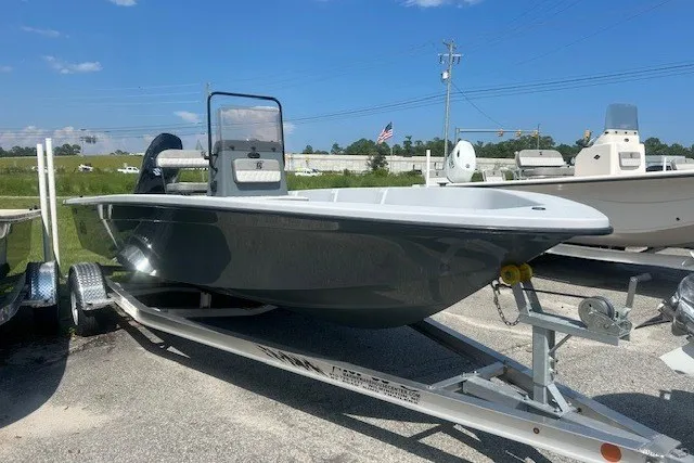 Slide: The Image of 2025 Carolina Skiff EV218 Sea Skiff on trailer, parked outdoors under clear blue sky. - 2