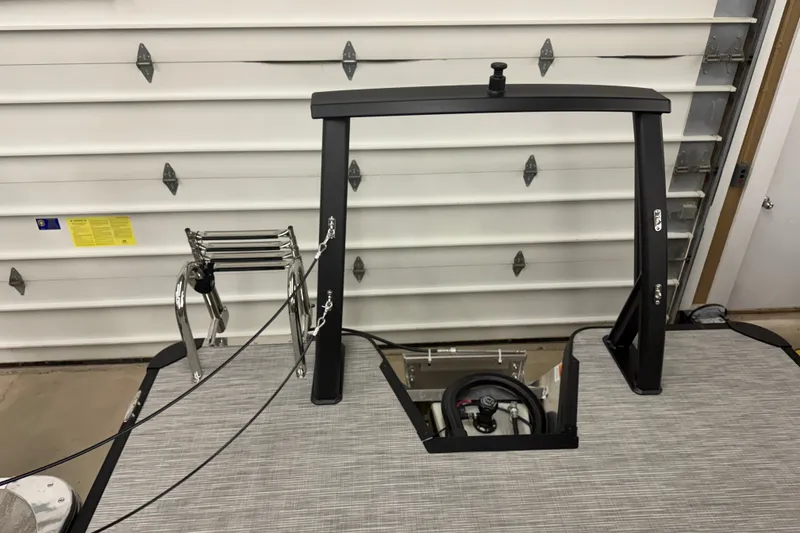 Slide: The Image of 2027 Crest Conquest 230 SLSC boat interior with ladder and steering wheel in garage. - 19