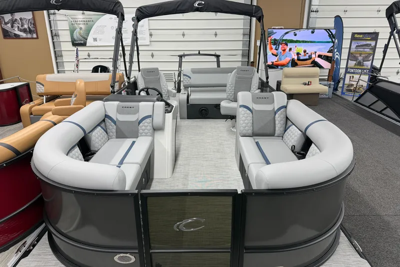 Slide: The Image of 2027 Crest Conquest 230 SLSC pontoon boat with luxurious seating in showroom display. - 1