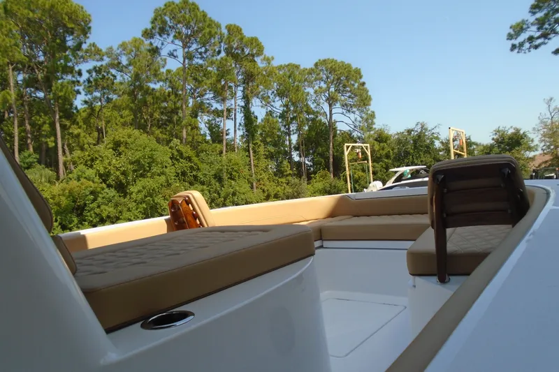 Slide: The Image of Luxurious 2027 STRIKING BOATS 26XB interior with tan seating, surrounded by lush greenery. - 9