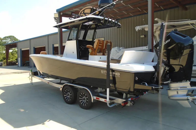 Slide: The Image of 2027 STRIKING BOATS 26XB on trailer, parked outdoors near a warehouse. - 23