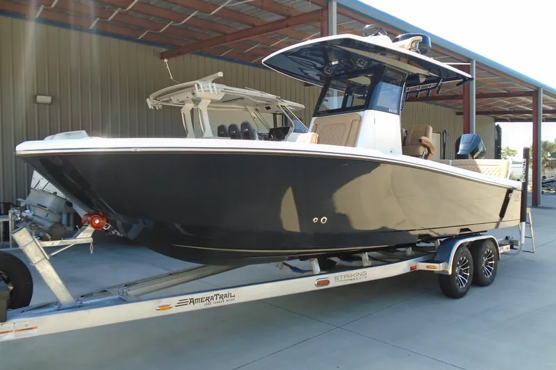 Slide: The Image of 2027 STRIKING BOATS 26XB on trailer, sleek design, parked in covered area. - 2